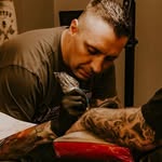 Jamie tattooing a client
